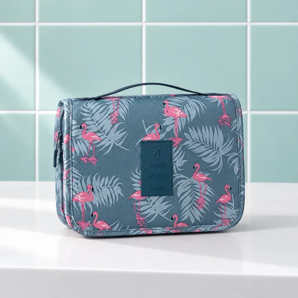 Trousse de toilette femme à suspendre à motifs, motif flamants bleus, fermée de trois quarts sur la tablette blanche